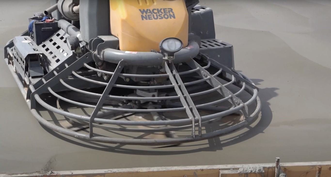 Professional power trowel machine finishing fresh concrete surface for smooth, durable results