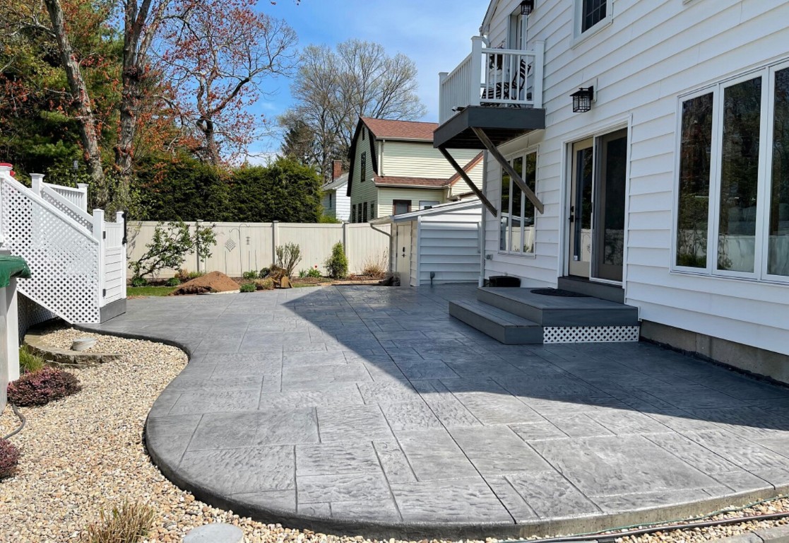 Stamped concrete patio in residential backyard with decorative pattern and professional finish